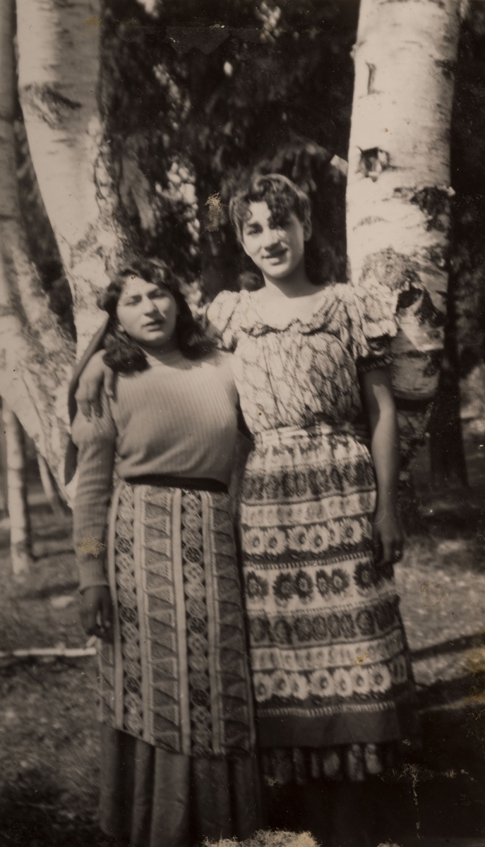 Två romska kvinnor är uppställda framför kameran, i juli 1950.