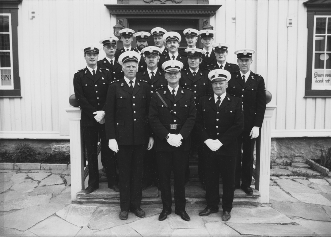 Femten uniformerte politifolk poserer utenfor et lensmannskontor. Trolig tilknytning til Uttrøndelag politidistrikt.