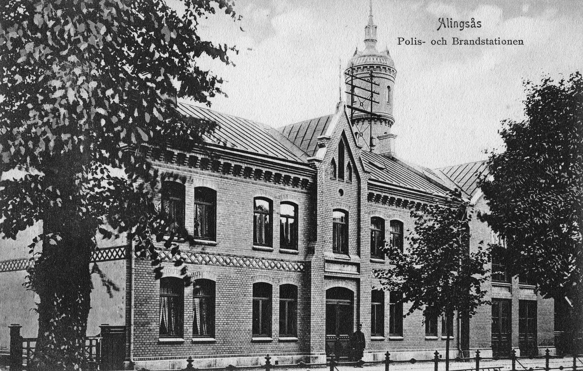 Vykort med Alingsås Polis- och brandstation vid Kungsgatan ca 1915. Byggnaden sedd från gatan.