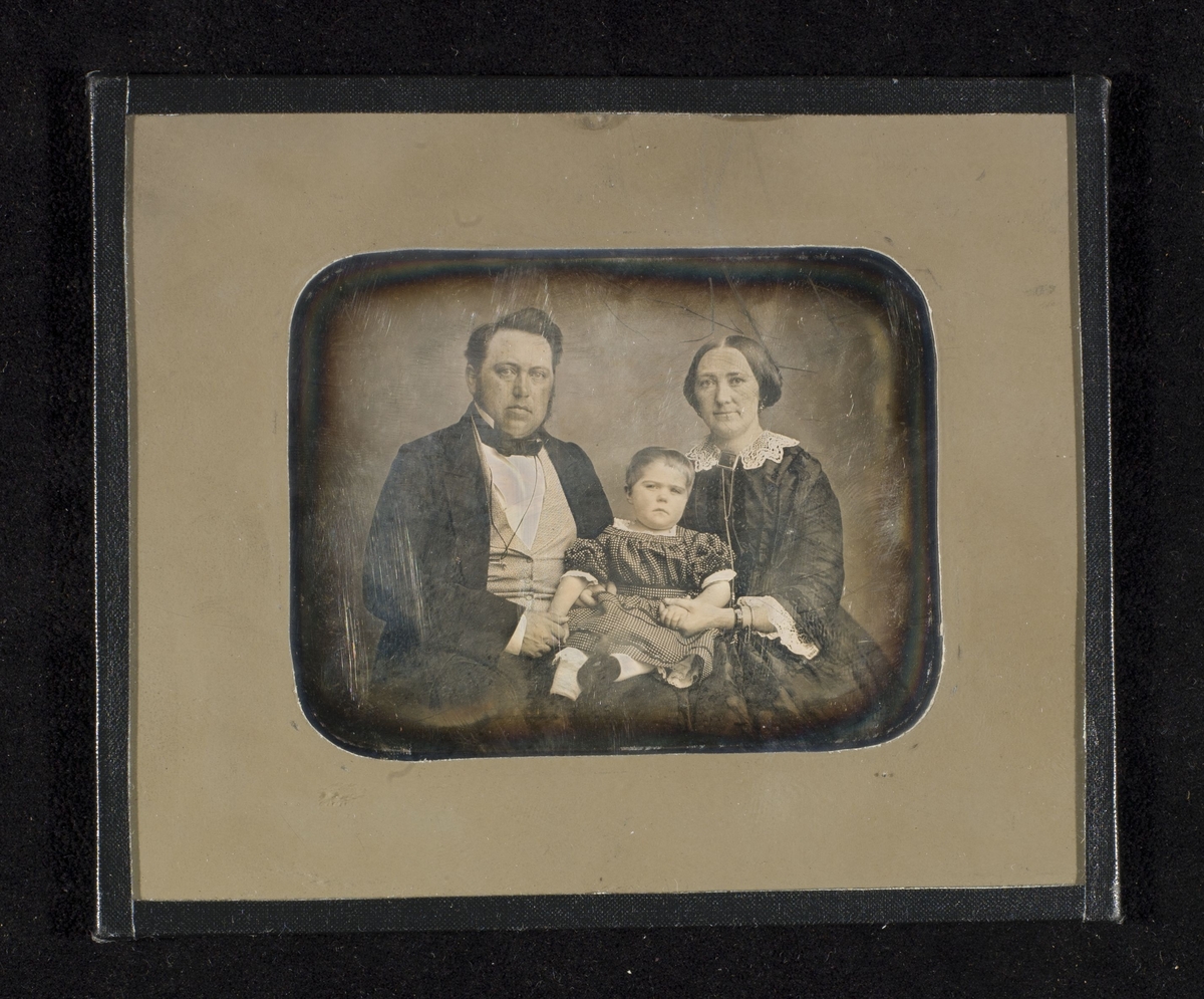 Daguerreotypi av foreldre med et barn i fanget.