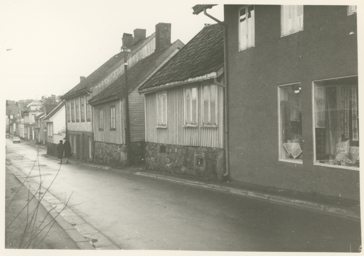 Skoggata. 
To bilder på samme kort. Fotograf har stått i Skoggata.
1966.
Historikk: Alle bygg på venstre side er revet til fordel for Kirkeparken VG. Alle på høyre side revet til fordel for boligblokker.