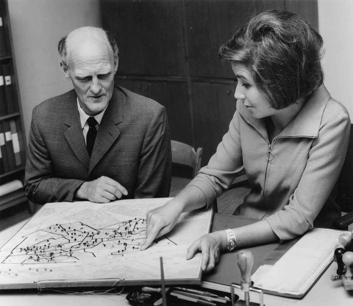 Postassistent Marta Kjellmodin och expeditionsförman Ture
Adestedt, Hägersten 1, diskuterar brevbäringsdistriktens utformning.
Foto 1968.