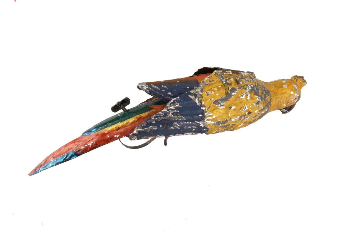 Mekanisk leketøy som kan trekkes opp slik at papegøyens vinger beveger seg.
