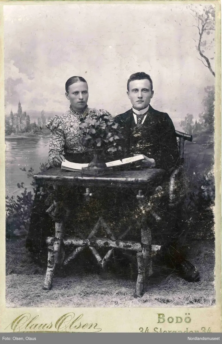 To unge personer, en kvinne og en mann sittende bak et bord laget av bjørk. Mannen er Benjamin Sjønøst.