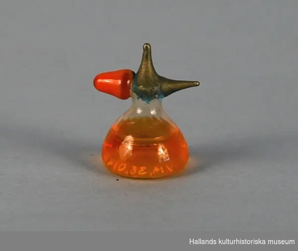 Leksaksparfymflaska, klockformad glasbehållare med gulaktig vätska. På toppen en efterhärmad pip och pump.
