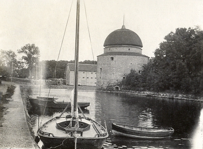 Hamnen i Vadstena, med några segelbåtar och en jolle.