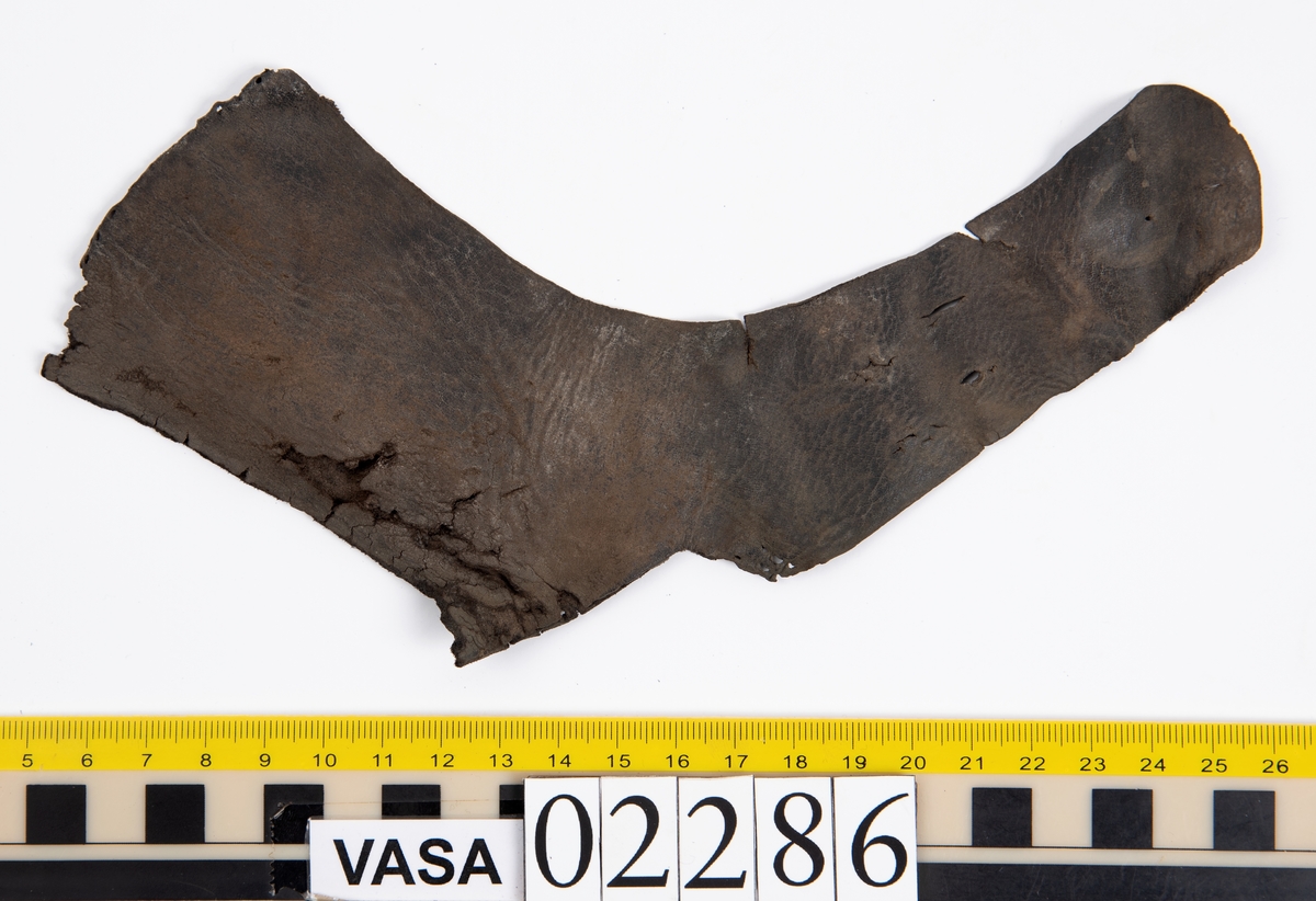 Två sidostycken från överdelen till en sko, i form av två sidostycken, samt ett mindre fragment som troligen spjälkats av från en av delarna. Längs med ena ytterkanten av fyndnummer 02286:1 löper stygnshål.
Lädret är spaltat och sprött.