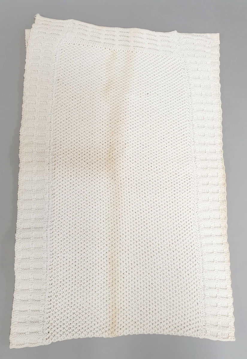 2 hvite håndstrikkede håndklær av bomull, som er gulnet i brettekant og på del av håndkleet.