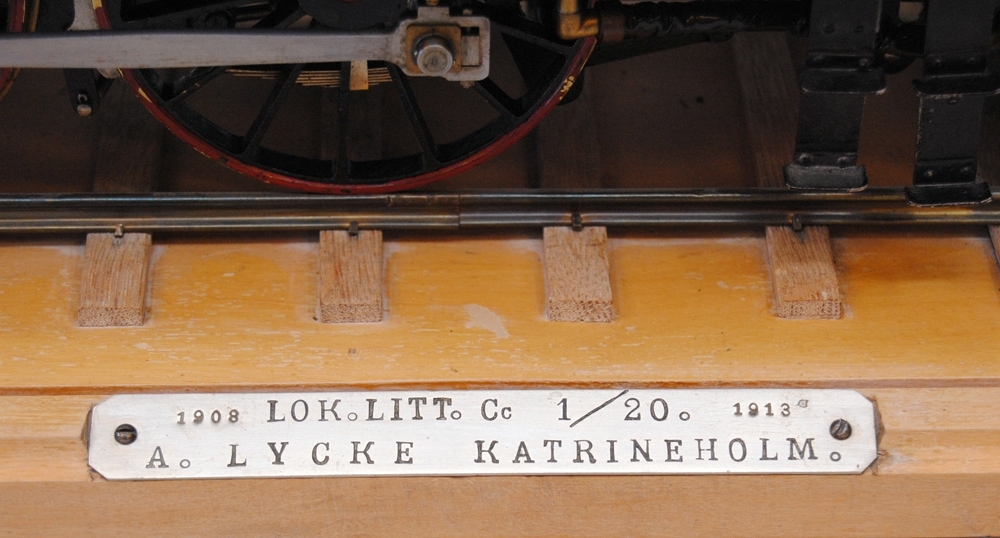Modell av ett ånglok i skala 1:20, tillverkat av f. d. lokföraren Alrik Lycke. 

Loket står på räls som är fäst på träunderlag (:2) (825x215mm). 
En metallplatta på träet har följande text: 
"1908 LOK.LITT Cc 1/20 1913
A. LYCKE KATRINEHOLM"