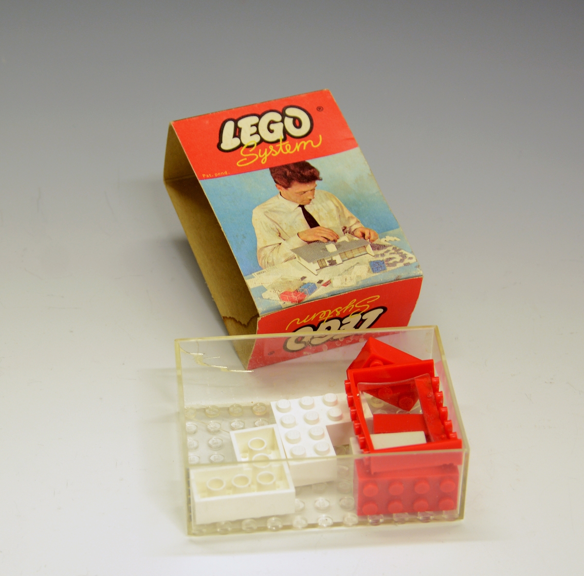 Originaleske i plastikk med "overtrekk" i papp. Ikke produsert som leketøy i utgangspunktet - bildet på esken viser en mann som bygger en modell av et hus i Lego.