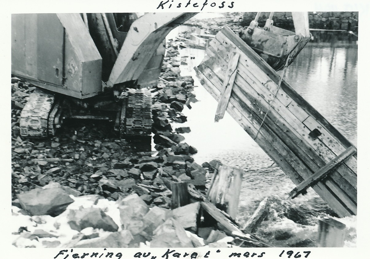 Gravemaskin fjerner trekonstruksjon fra tømmerinntaket, kalt Karet, på Kistefoss.