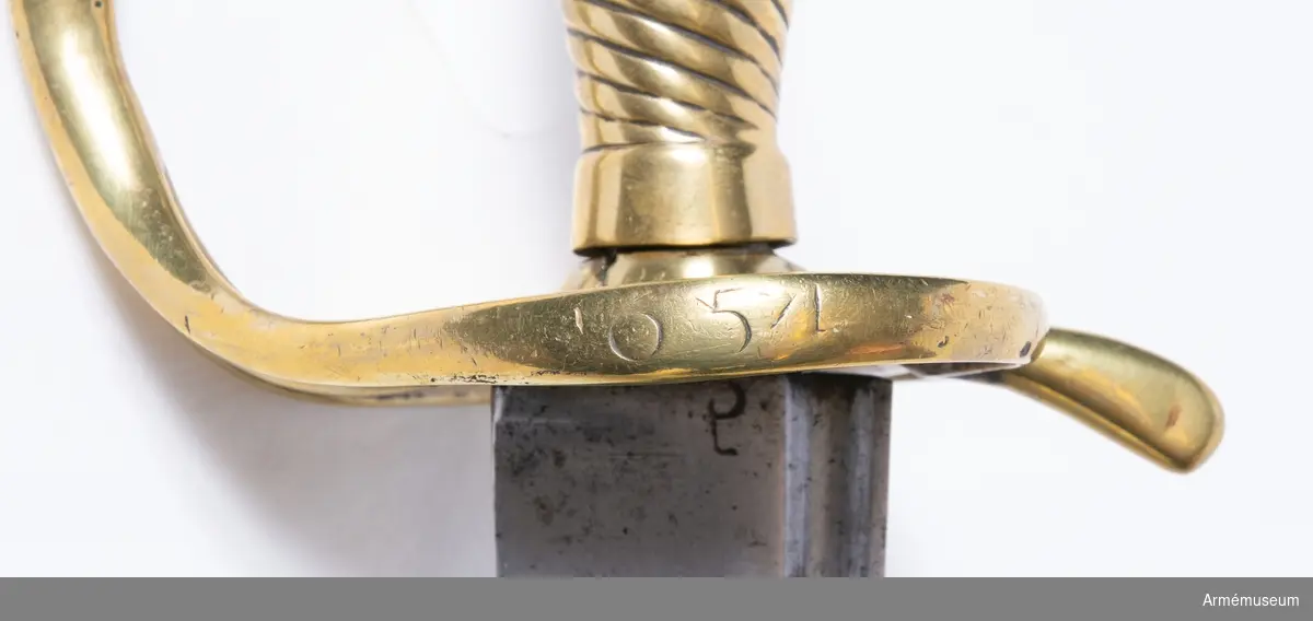 Grupp D II.
Huggare m/1748 för infanteriet. Huggaren är mycket lik AM 60188. Upptill på klingans yttersida finns en P-stämpel. Parerplåten är ovanligt tunn och knappen är liten, varjämte parerstången är rätt tunn. På parerplåtens ytterkant står numret 654. Den skruv, som skulle hålla fast handbygelns övre ände vid knappen, fattas.