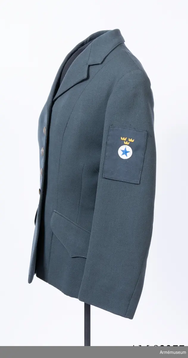 Jacka sydd i mörkblått ulltyg med märke för Svenska Blå Stjärnan på vänster ärm.