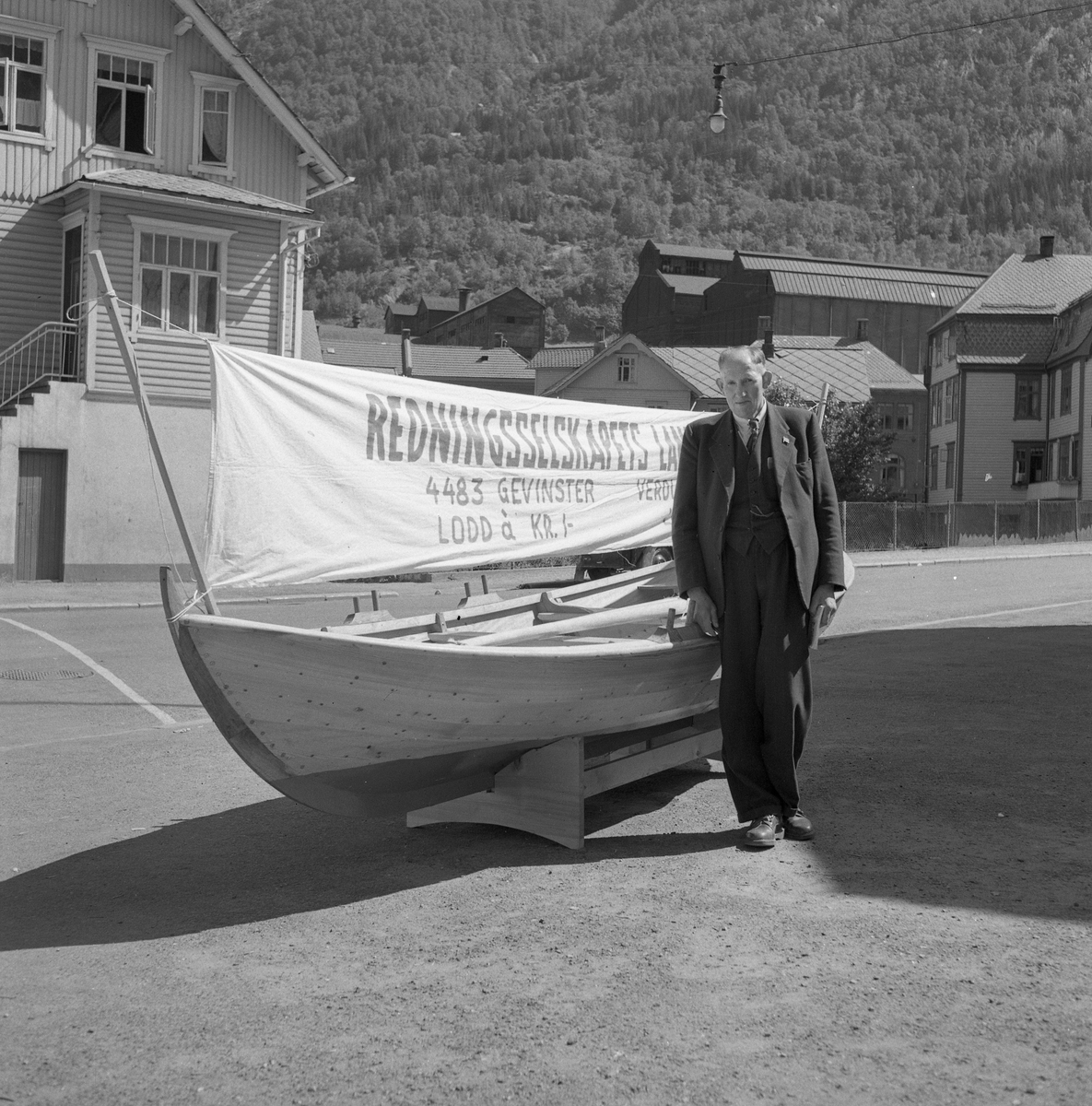 Redningsselskapet Landslotteri, utlodding av robåt. Lodd til 1 krone. Torget i Odda sentrum 24/7-1954. 