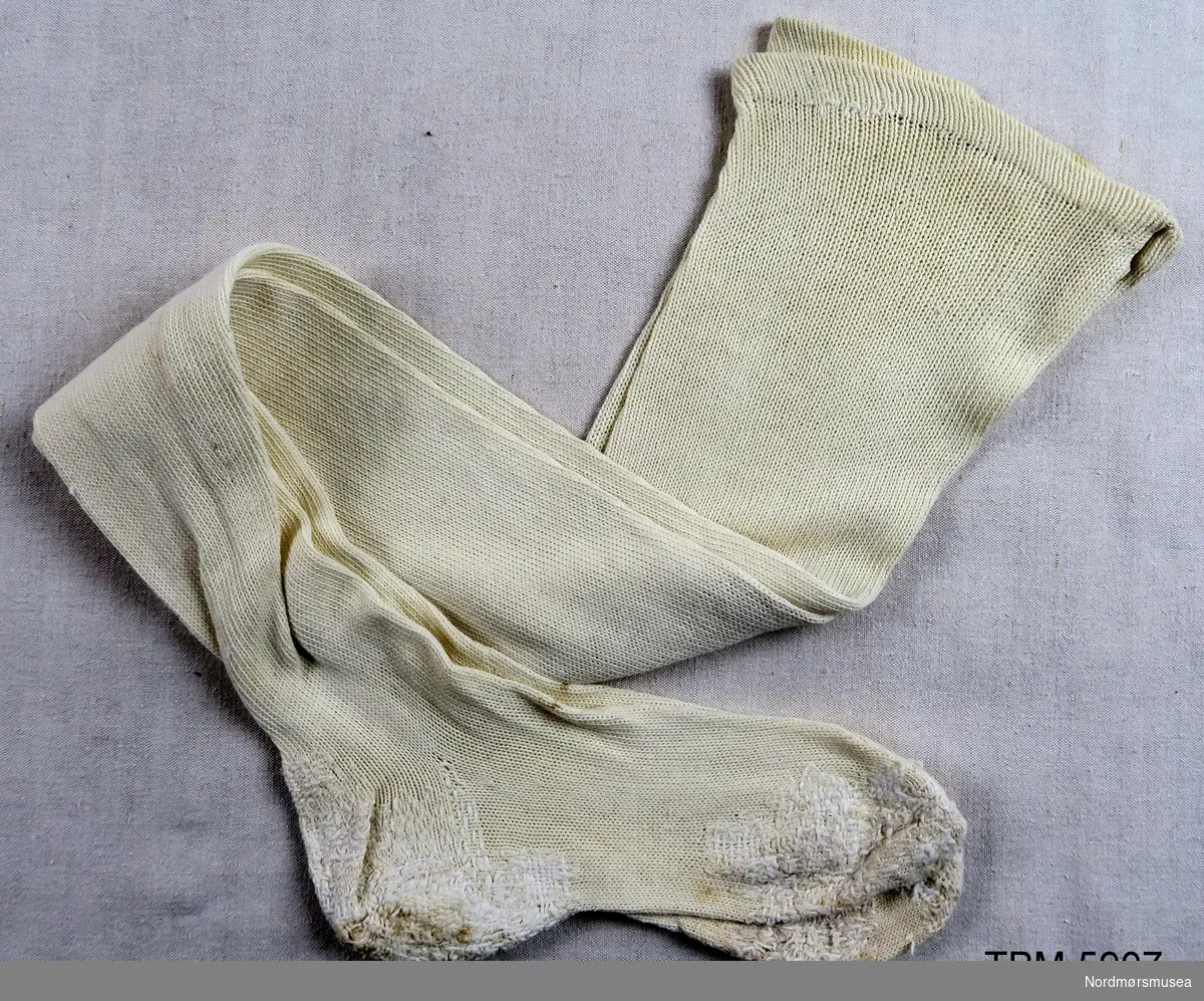 Kvite damestrømper. Foten er svært stoppa. Kan være brukt under krigen av sjukepleiar Gudrun Drøpping.