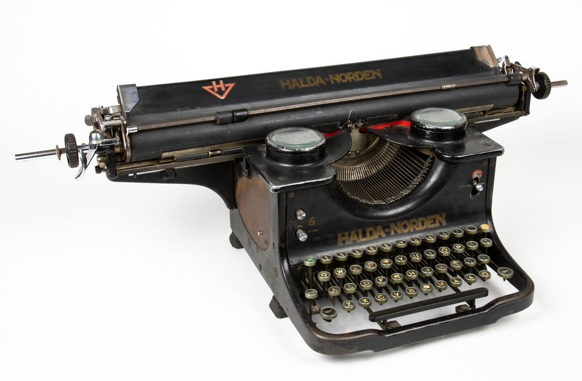 Manuell skrivmaskin av märket Halda-Norden i svart metall med  lång vals.