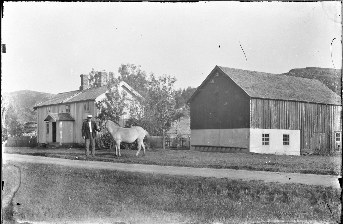 Fartøyskipper Andreas Bernhardusen Rønning med hesten foran gården sin Eidet, Asserøya