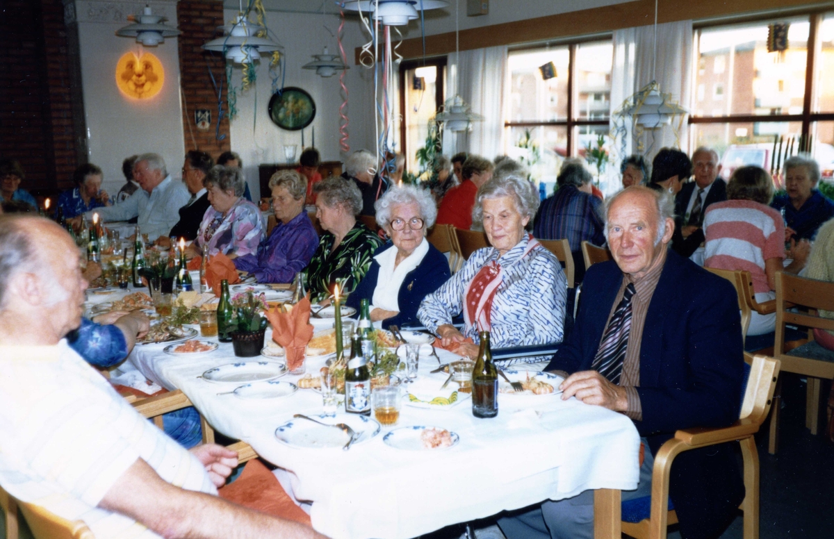 Kräftkiva i Brattåsgårdens matsal, cirka 1990.
Från höger: Alvar Andersson (med slips) och bredvid sitter hustrun Elsa (med röd halsduk).