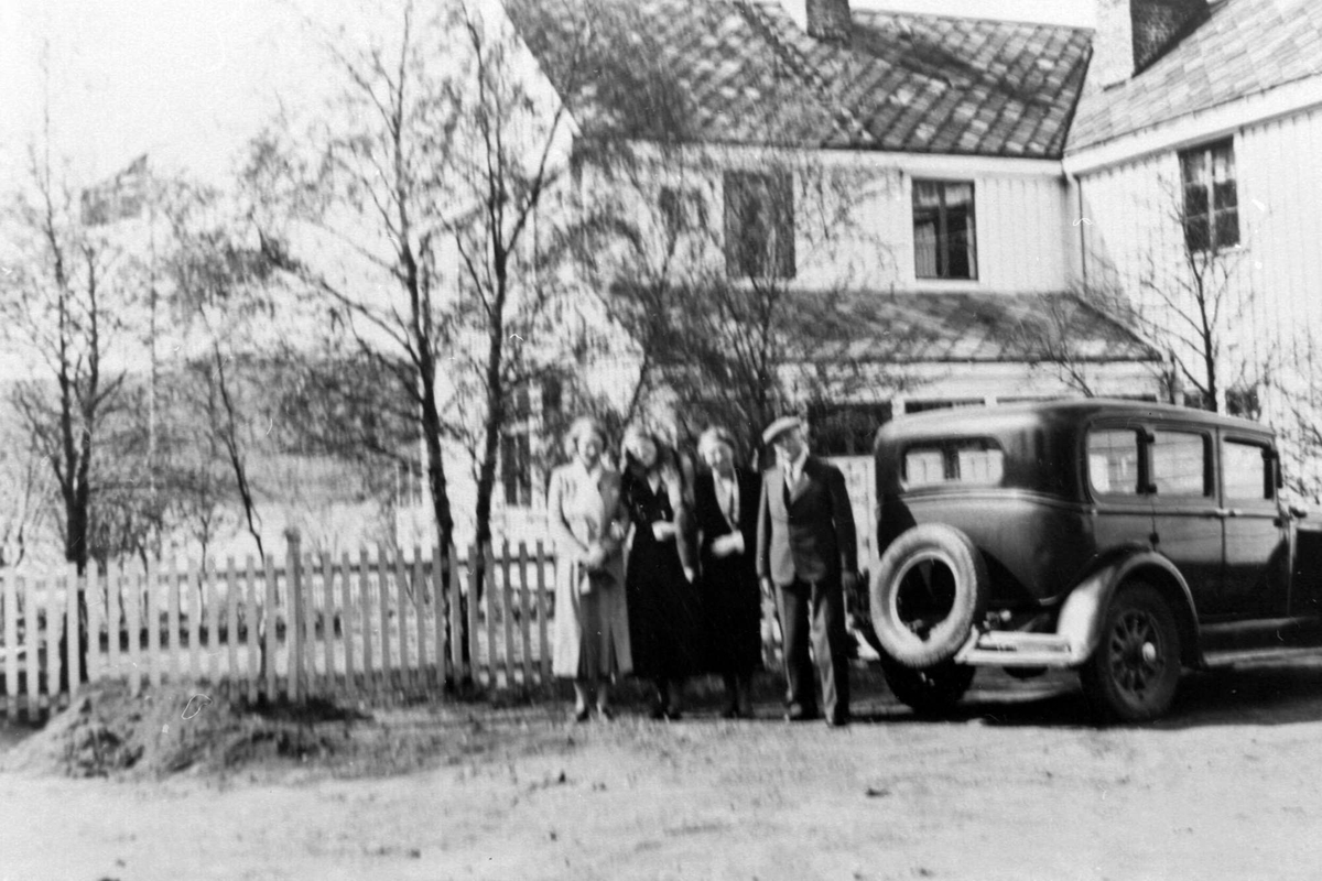 Fire personer står ved en bil foran Fochsengården på Borkenes.