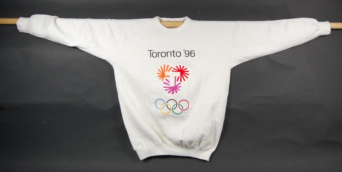 Hvit genser med flerfarget logo for kandidatbyen Toronto i forbindelse med søkerprosessen til de olympiske leker i 1996.