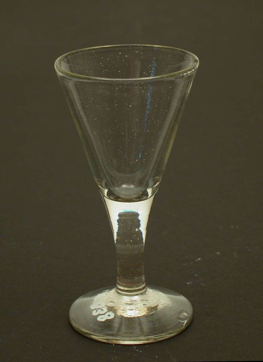 Spissglass. Glasset har et svakt grønnskjær. Glasset er sprukket og har et hakk i randen.