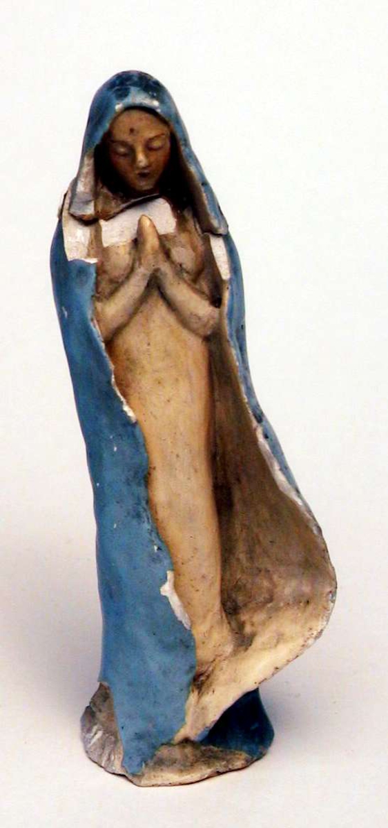 Madonnafigur i lys blå kappe. Figuren er laget i gips. 