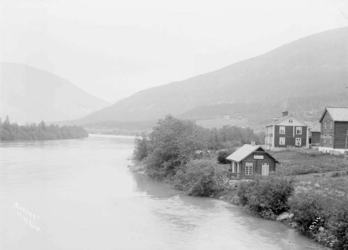 07.07.1909. Utsikt fra Sundbroen. Elv, boliger, uthus (bl.a. badstue).