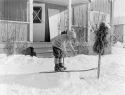 Liten gutt på ski utenfor hus. Vinteren 1929. Gunnar Berge.
