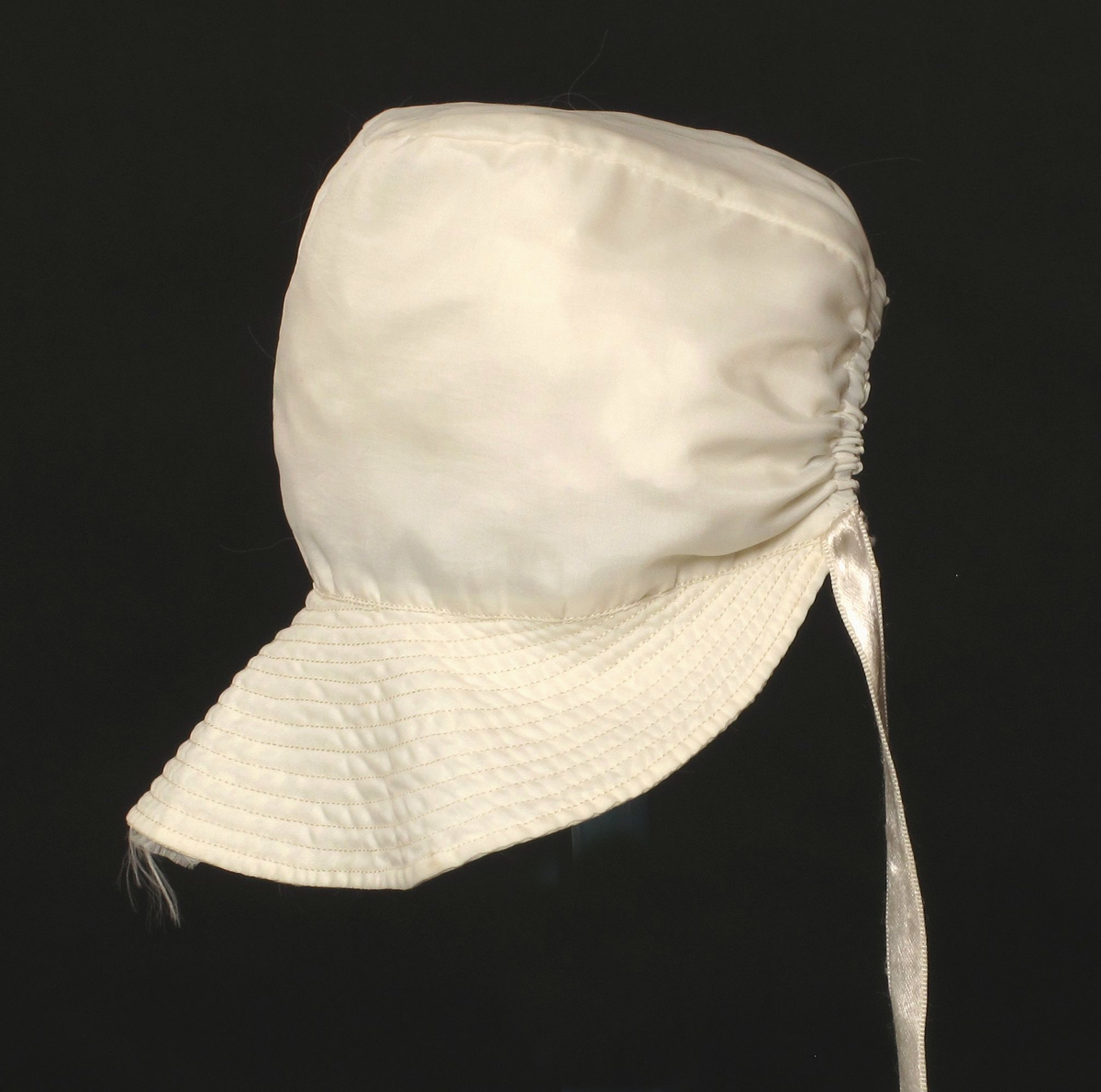 Småbarnlue sydd av hvit fallskjermsilke.