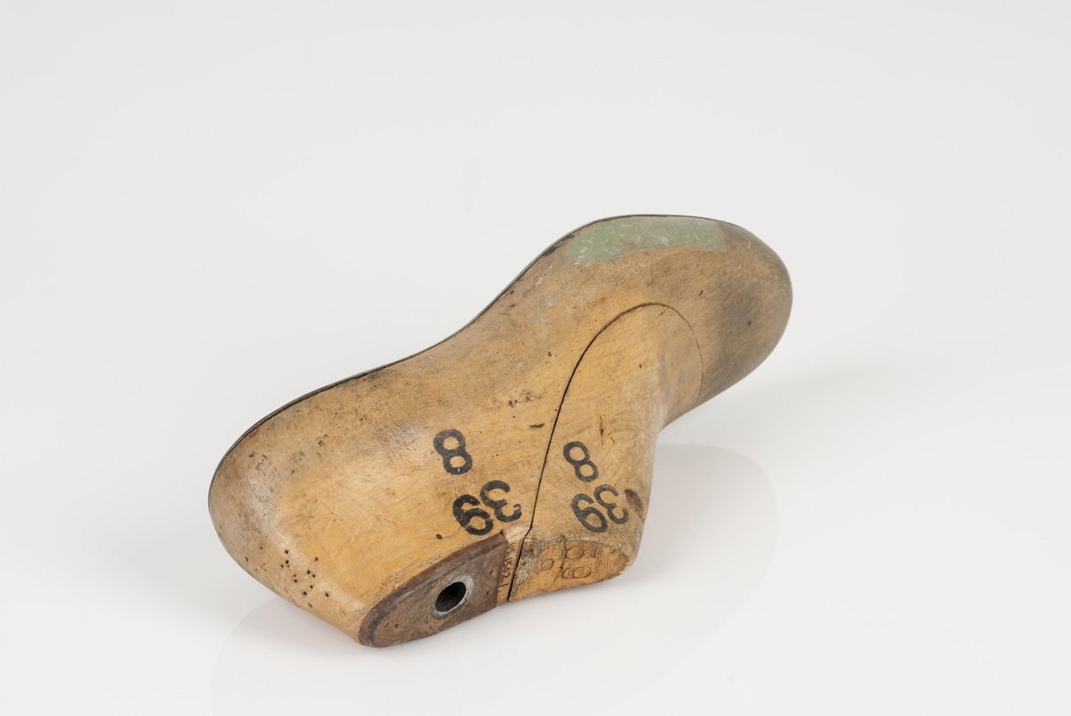 En tremodell i to deler; lest og opplest/overlest (kile).
Venstrefot i skostørrelse 39, og 8 cm i vidde.
Såle i metall.