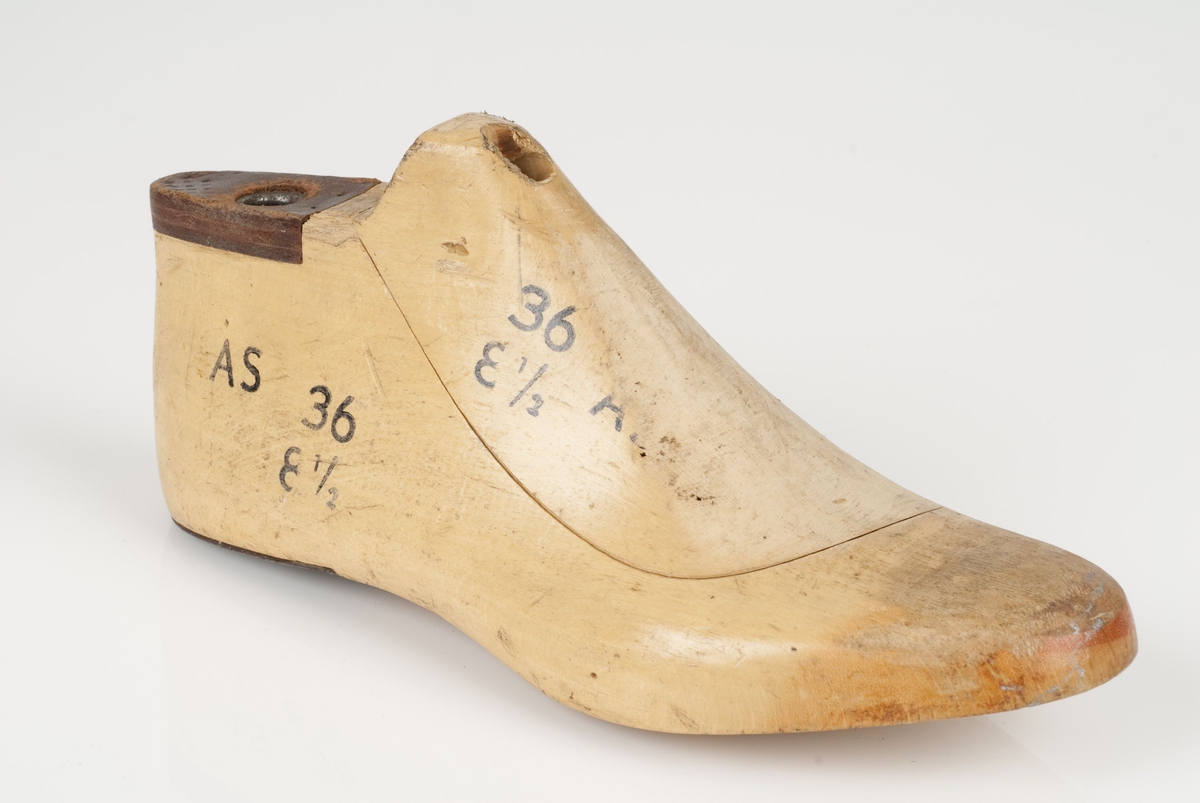 En tremodell i to deler; lest og opplest/overlest (kile).
Høyrefot i skostørrelse 36, og 8,5 cm i vidde.
Lestekam av skinn
Hælstykket av metall.