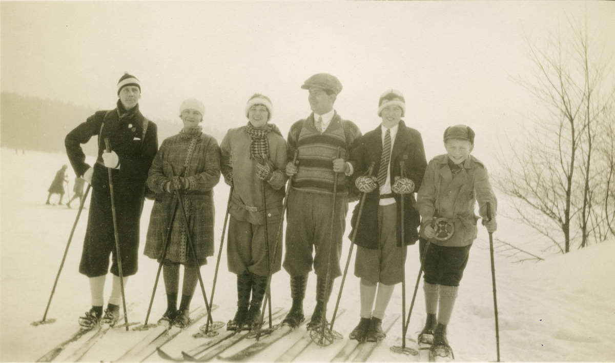 To menn, tre damer og en gutt på ski.