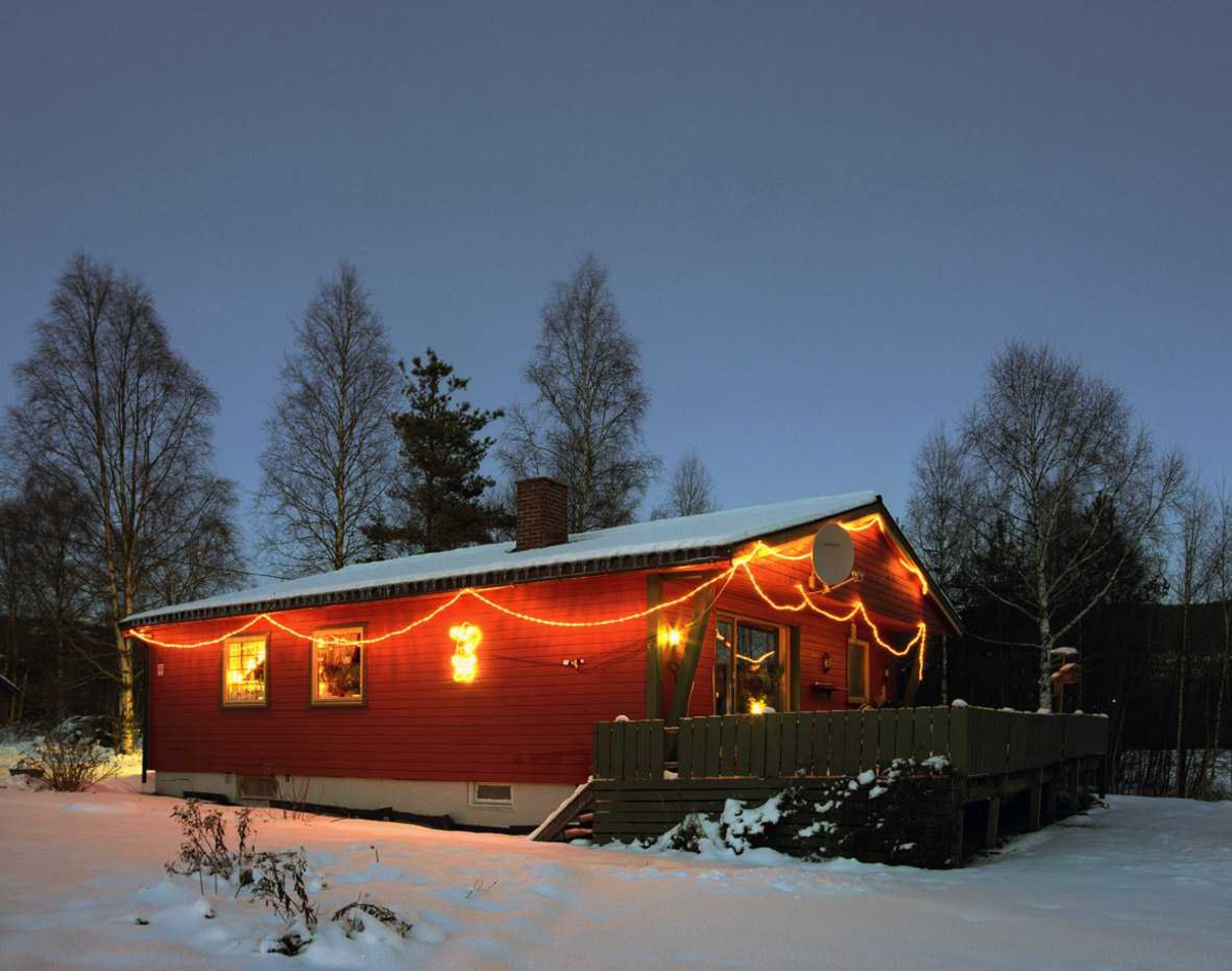 Julebelysning.

Rød lysslange hengt i girlander og lysfigur på vegg på enebolig.  
