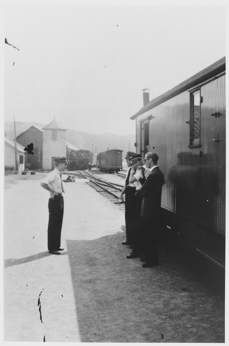 Stasjons- og togpersonale på plattformen under togets opphold på Bjørkelangen stasjon. Lokomotivet har gått rundt toget for å fylle vann fra søndre vanntårn.