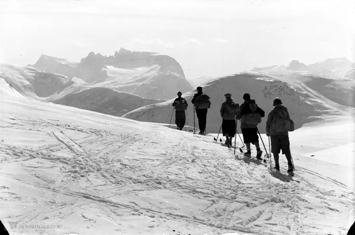 Trolltindene med 5 skiløpere ved Kjelskaret..Trollveggen med Bruraskaret i bakgrunnen.
