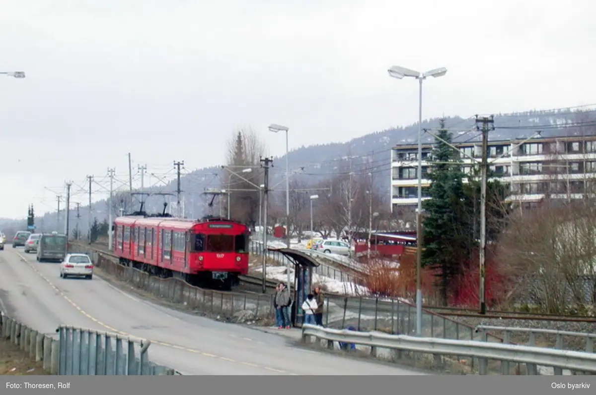 Oslo Sporveier. Kolsåsbanen. T-banevogn, serie T7, vogn 1337 på linje 4, her fra Kolsås mot Hauger langs Brynsveien. Busskur med ventende.