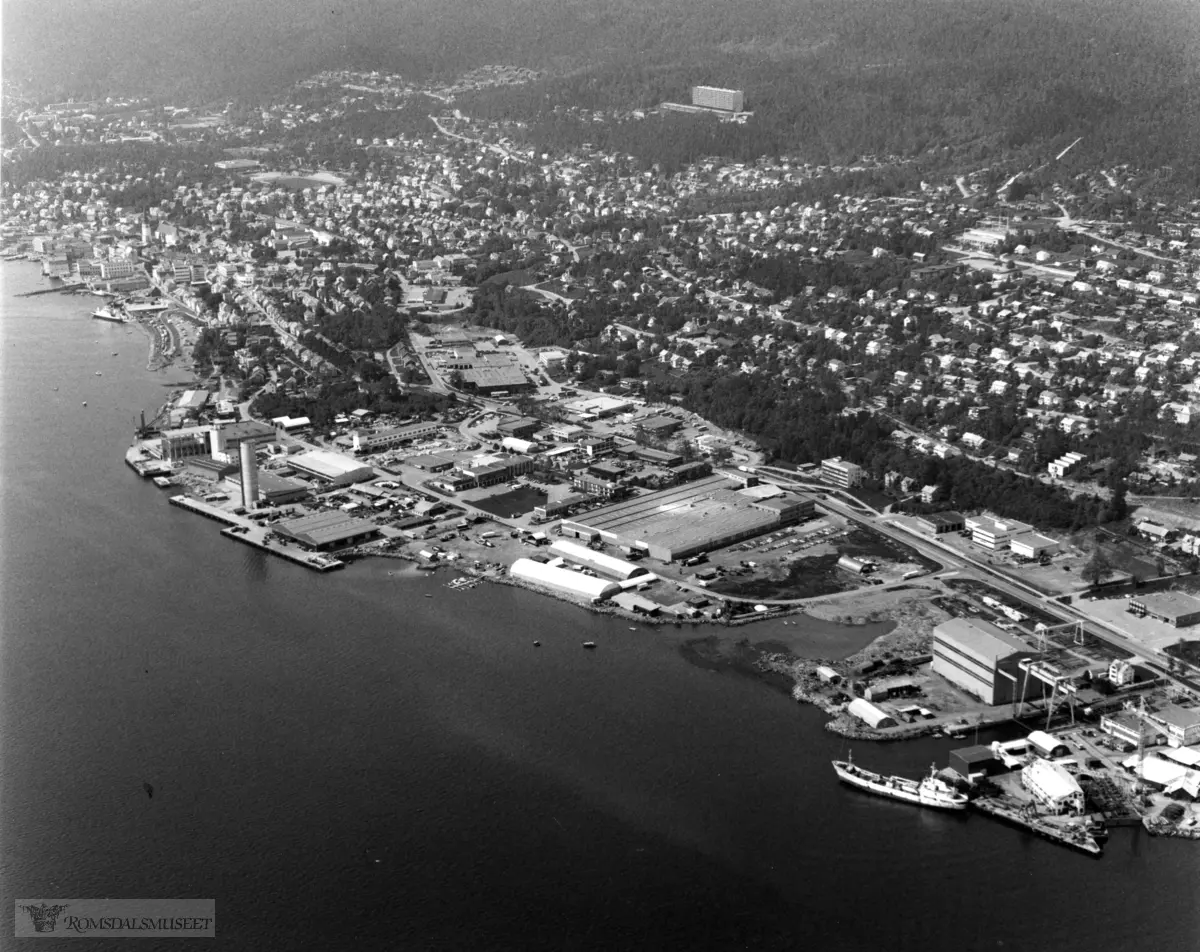 Molde sentrum øst, havneområdet med Grandgården bak og den gamle slateritomta (gilde), Stålprodukter, kornsiloen, Glamox, Bolsønes verft lengst til høyre. Hatleli blokka øverst i bildet..(Trykt i RB 25/1-1989)