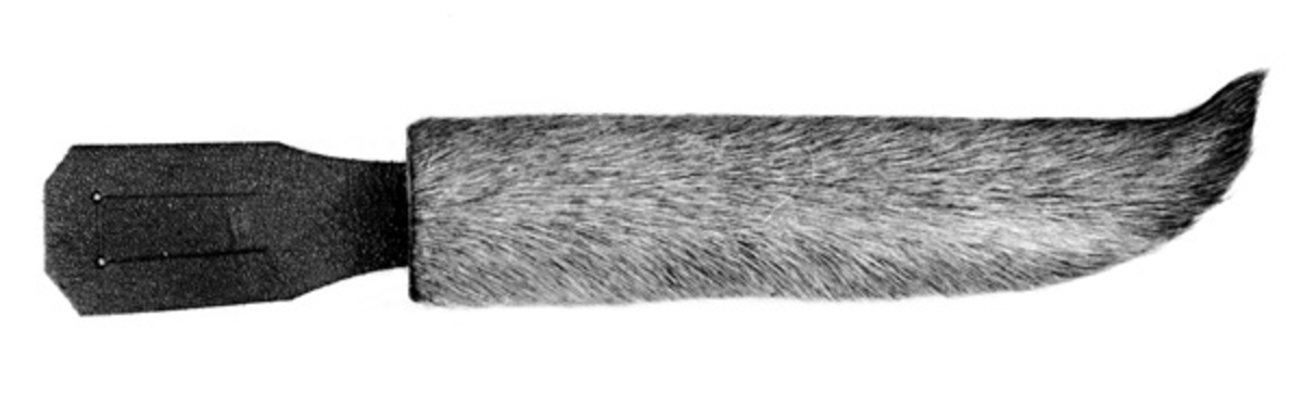 Slire til en relativt langbladet kniv, lagd av Aanon Dalane (1908-1998) fra Gjerstad i Aust-Agder. Slira er J-formet og drøyt 18,5 centimeter lang. Utvendig bredde ved sliremunningen er 4 centimeter. Slira består av ei innerslire av brunt lær, og utenpå denne er trukket elgskinn med håra på. Håra er nedvervendte når slira henger i opphenget, en brunfarget lærstropp med to vertikale spalter som kan tres inn på et belte.
