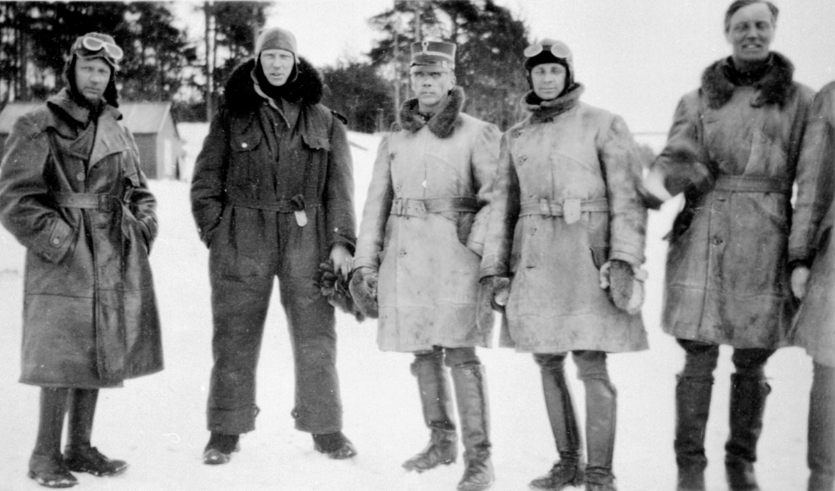 5 flyvere i skinnklær. Fra venstre er løytnant Sundby, Øen, Normann, Clason, Motzfeldt. Flyskolen på Kjeller hadde øvelse på Mjøsisen ved Nerkvern gård, Brumunddal.