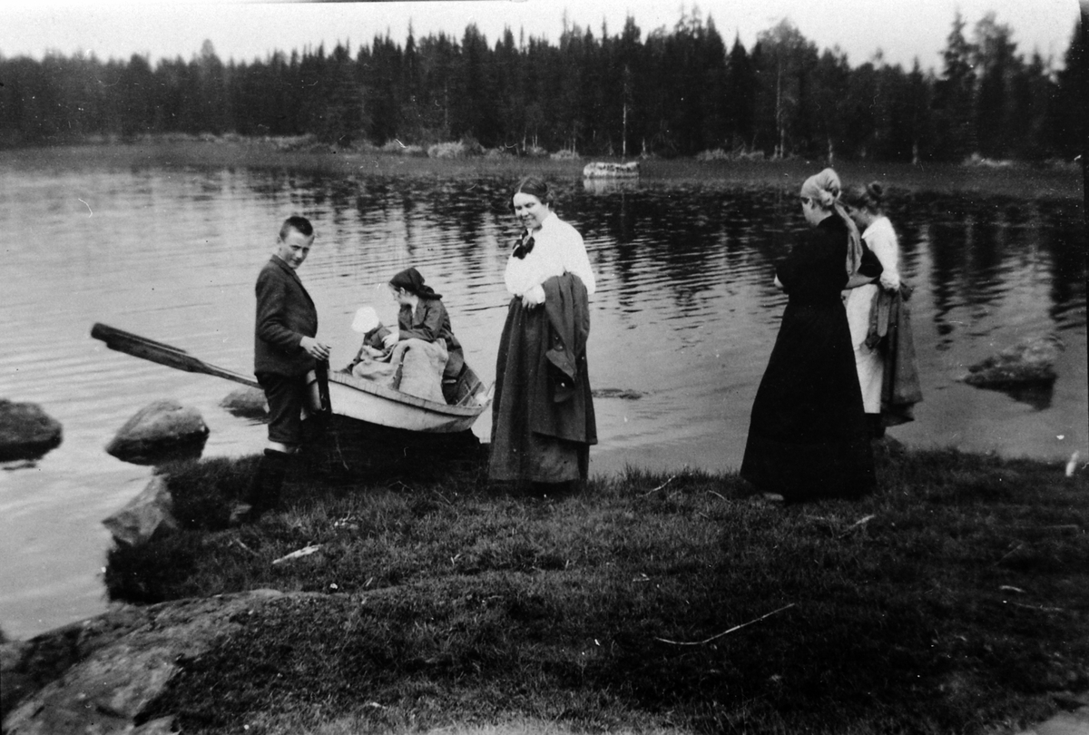 Gruppe voksne og barn ved robåt på Sør-Mesna, Ringsaker.