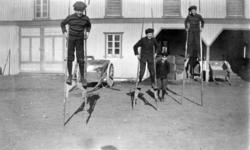 BARNELEK, 3 GUTTER GÅR PÅ STYLTER, ÅLSTAD GÅRD