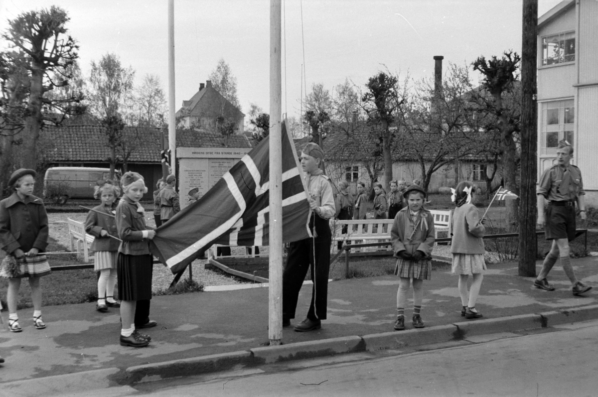 STANGE, 17 MAI, SPEIDERE VED MINNESMERKE OVER DE FALNE 1940-1945, FLAGGHEISING. Asbjørg Skjegstad til høyre med trompet og 17.mai-sløyfe.
