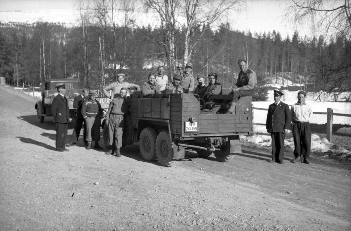 To kjøretøyer med flere menn rundt.
Bakerste bilen kan være en Krupp L2H143 Kfz.70 med tyske WH-skilter (Wehrmacht Heer).