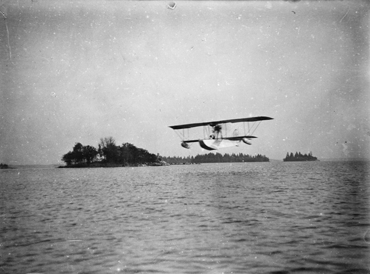 Flygplan Donnet-Lévêque flyger på låg höjd över vatten. - Flygvapenmuseum /  DigitaltMuseum