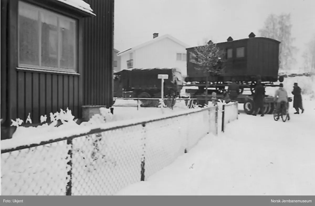 Flytting av Kongsvingerbanens kongevogn, opplastet på henger bak lastebil, utenfor Løvliens hus