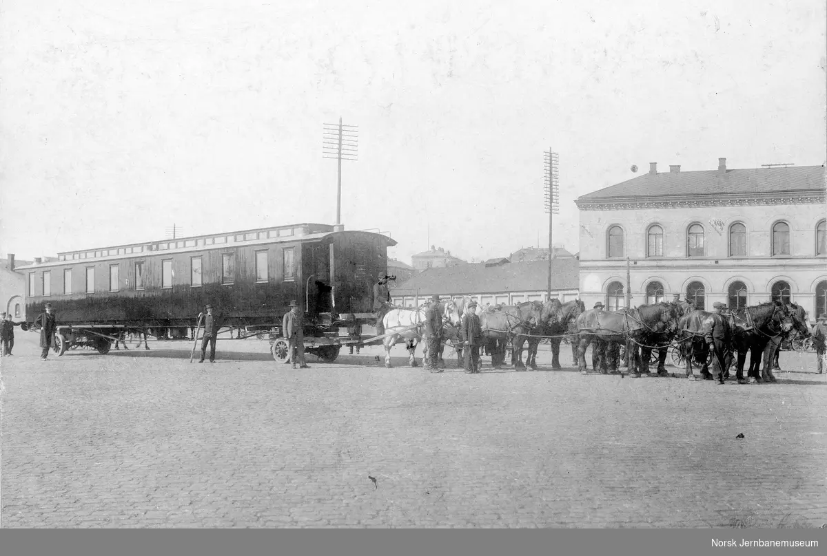 Transport av ny jernbanevogn til Hell-Sunnanbanen, trukket av åtte hester, utenfor Vestbanen