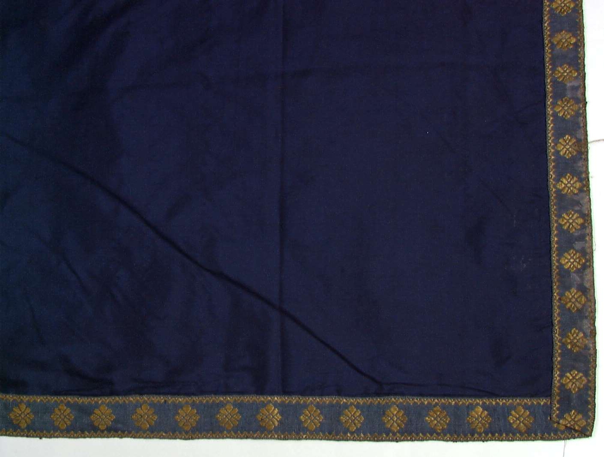 Blå sengeforheng av silke, dekor av blå - gule mønstervevde bånd.