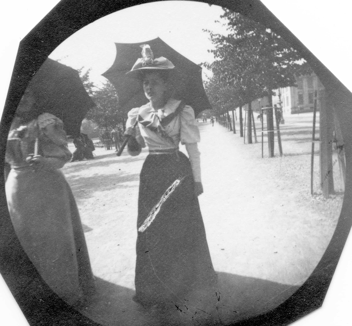 Frk. Krohn fra Bergen og en annen kvinne spaserer i Studenterlunden. Oslo, Universitetet skimtes.