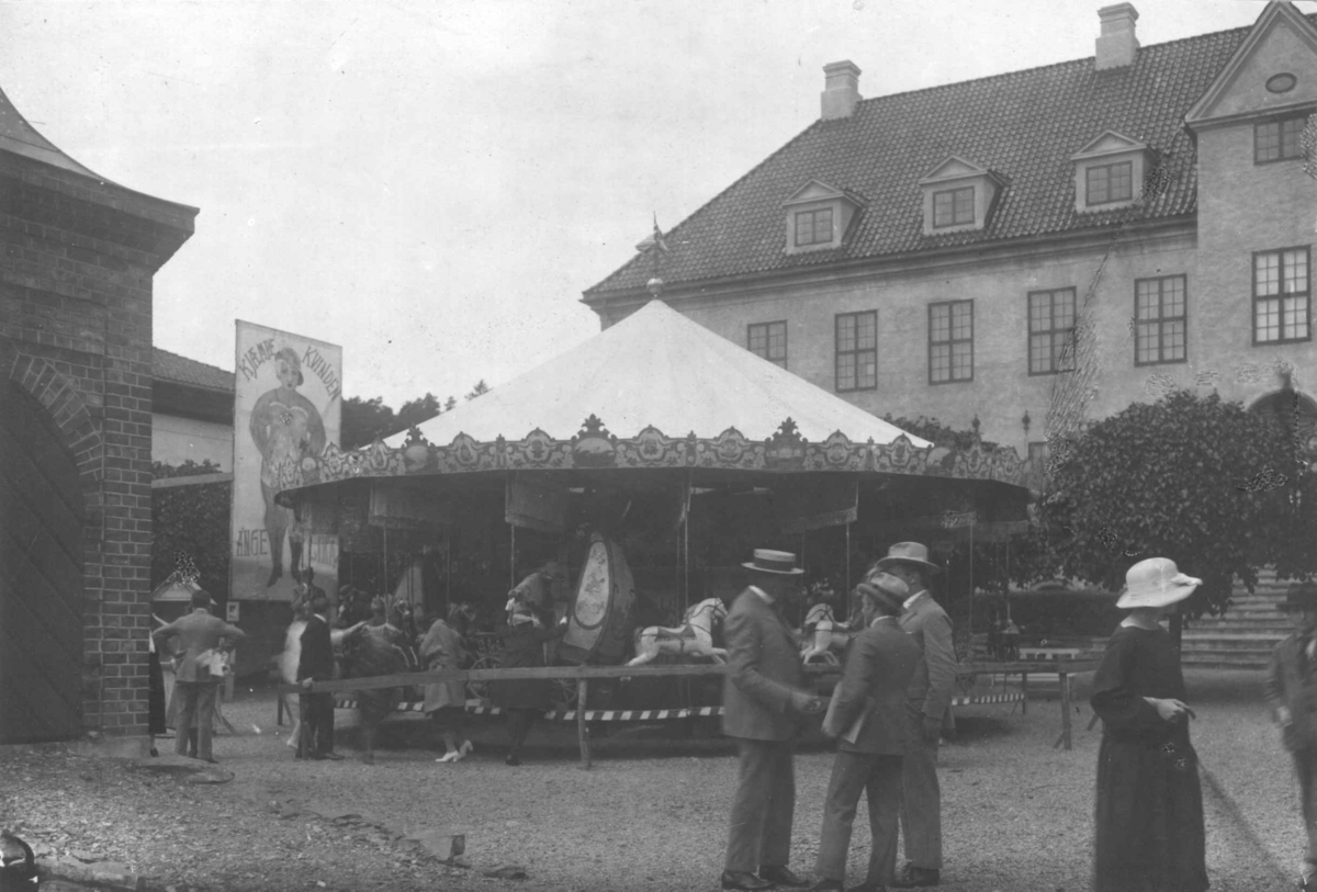 Torvet med karusell og mennesker på markedstilstelning i 1922 på Norsk Folkemuseum.