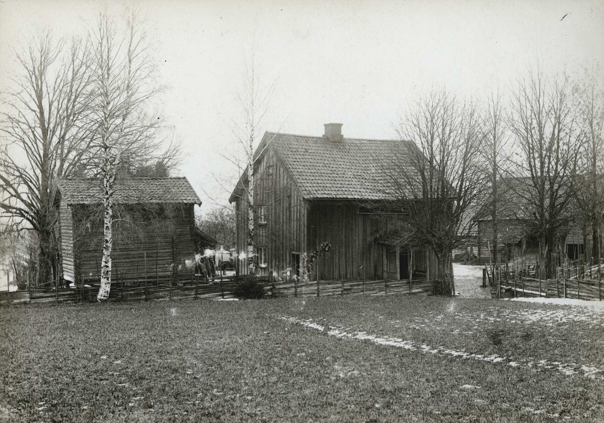 Mathises, Eidsvoll, Øvre Romerike, Akershus. Gårdstun med våningshus og uthus sett fra et jorde.